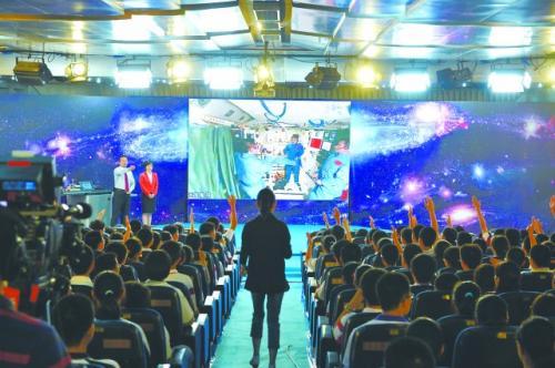 20日上午,在中国人民大学附属中学太空授课地面课堂,学生们举手向航天员王亚平提问。
